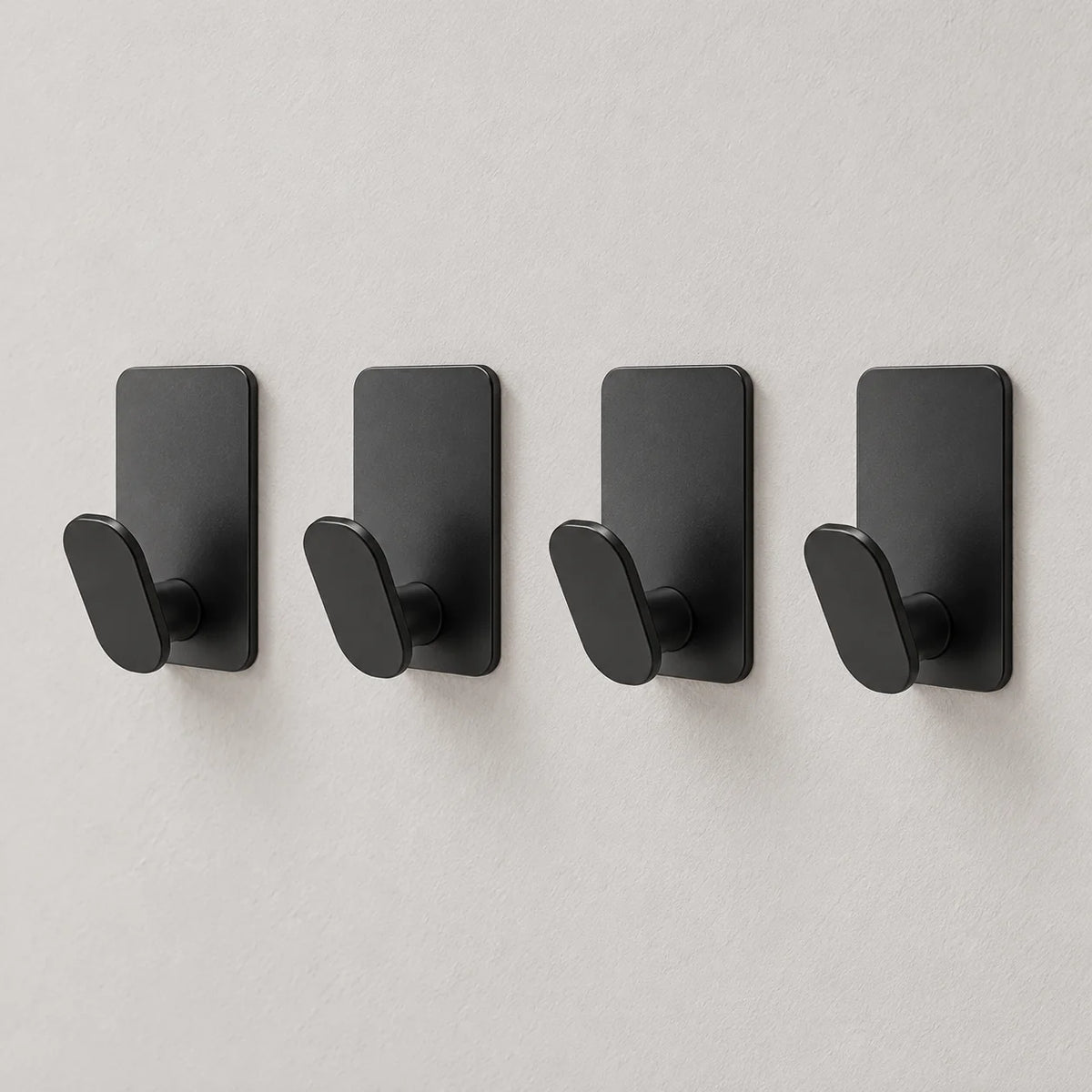 Lot de quatre crochets de salle de bain noirs sur fond gris