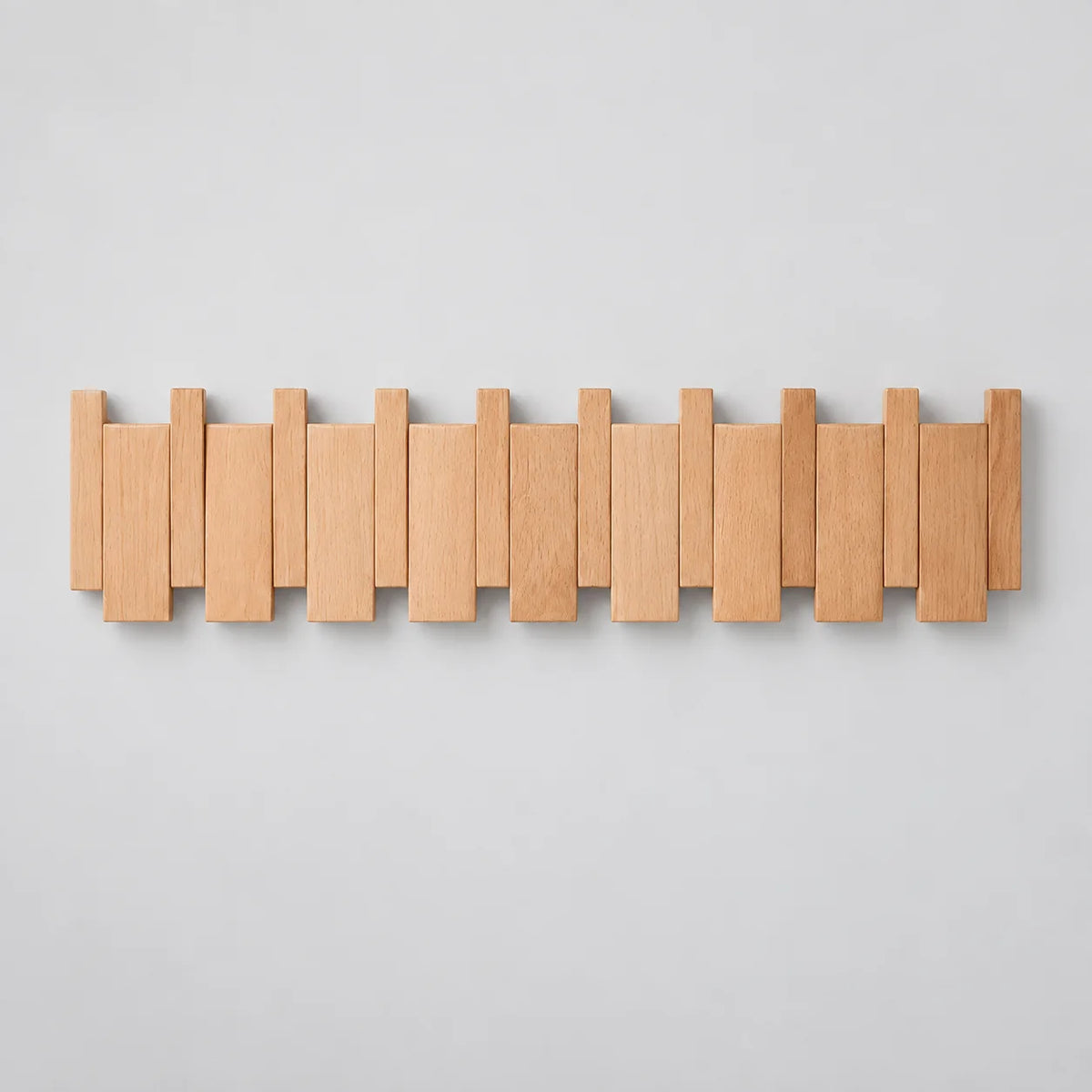 Grand porte-manteau mural en bois de hêtre clair à lames alternées sur fond gris