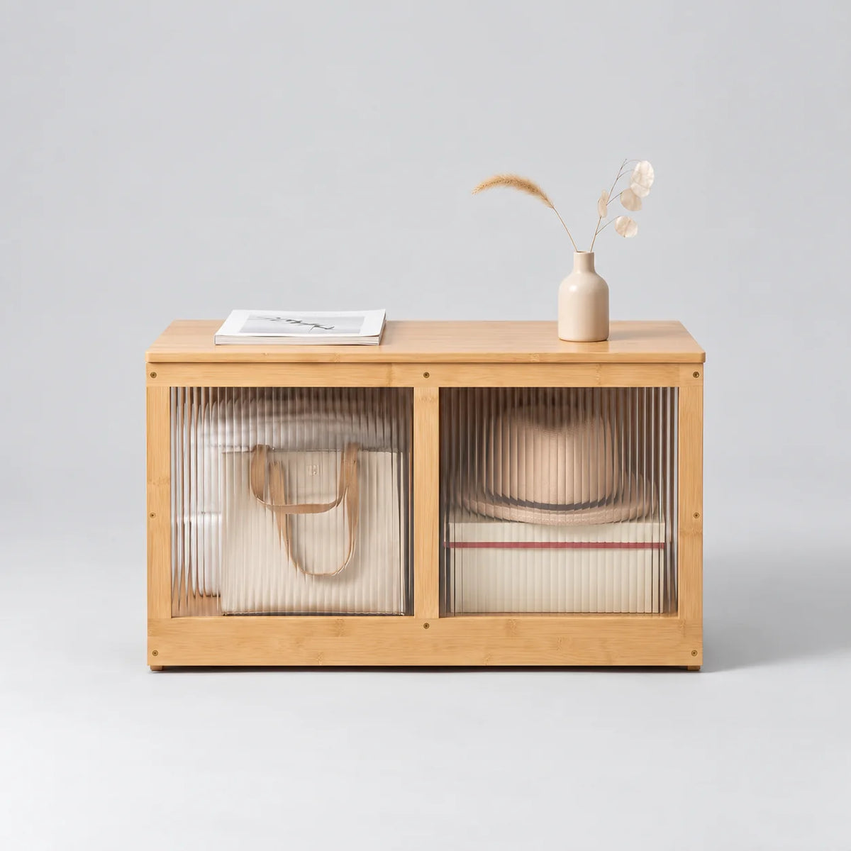 Meuble à chaussures bas en bambou bois clair avec deux façades cannelées transparentes sur fond gris Image
