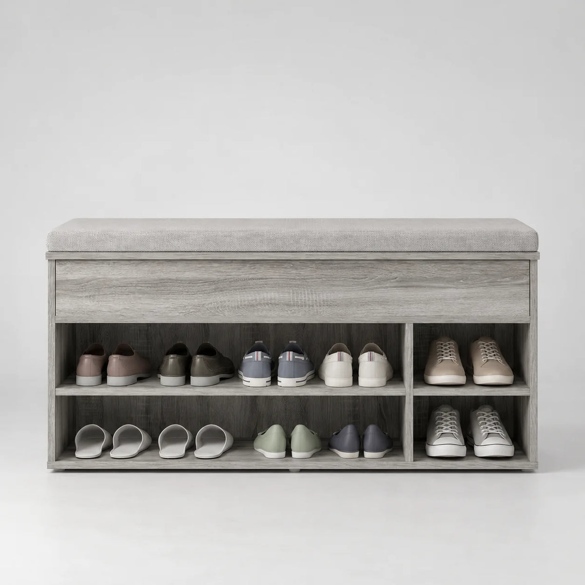 Banc à chaussures en bois gris patiné à étagères ouvertes et coussin gris sur fond gris
