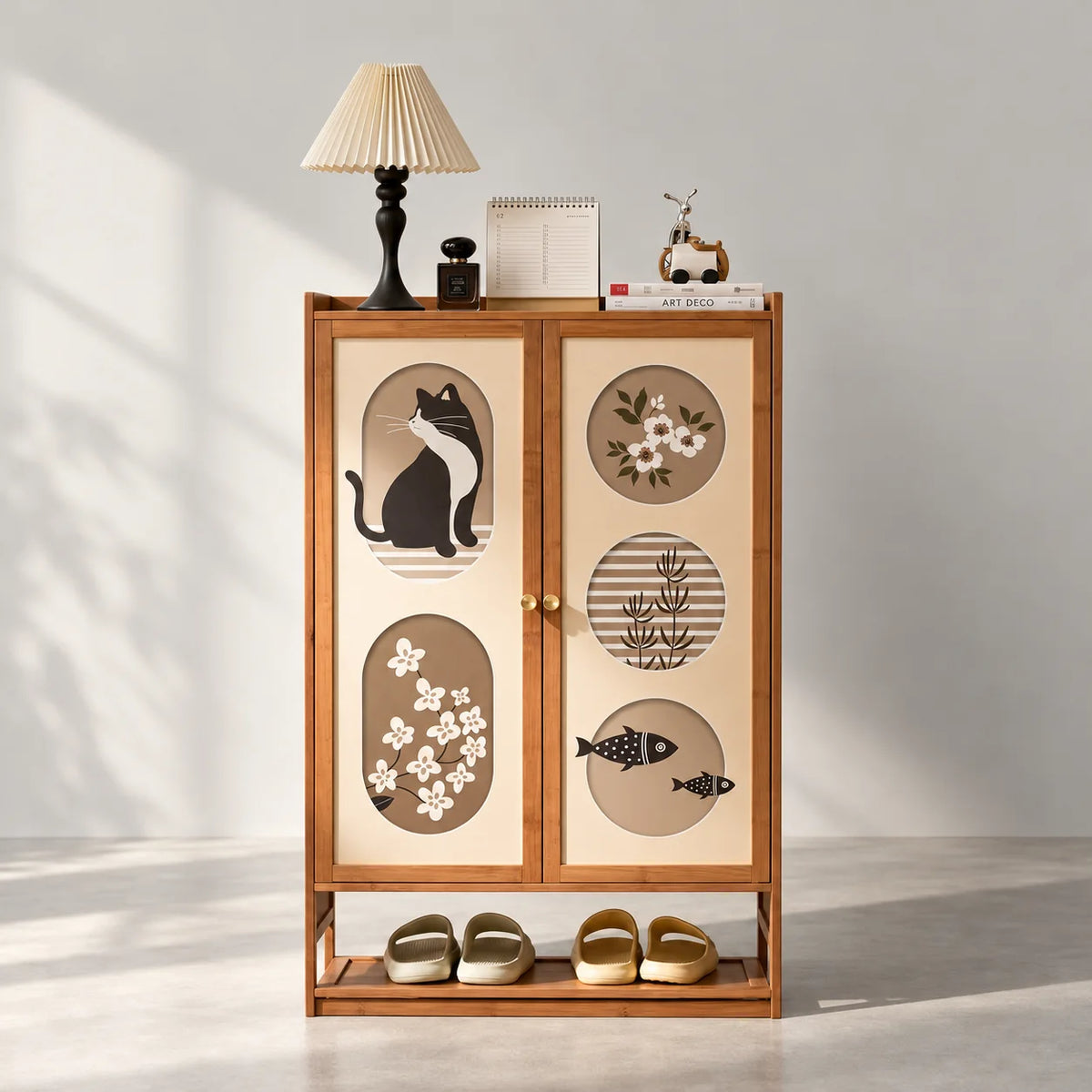 Meuble à chaussures en bambou brun à deux portes décorées de chat, fleurs et poissons sur fond gris Image