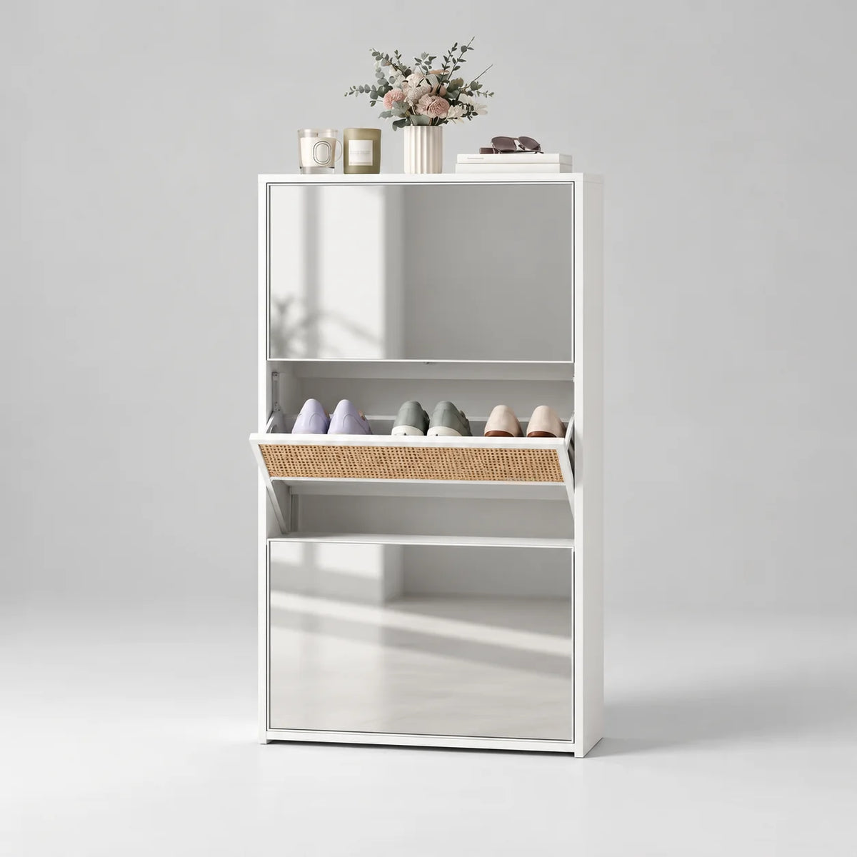 Meuble à chaussures blanc et miroir à trois compartiments dont le compartiment central est ouvert sur fond gris Image