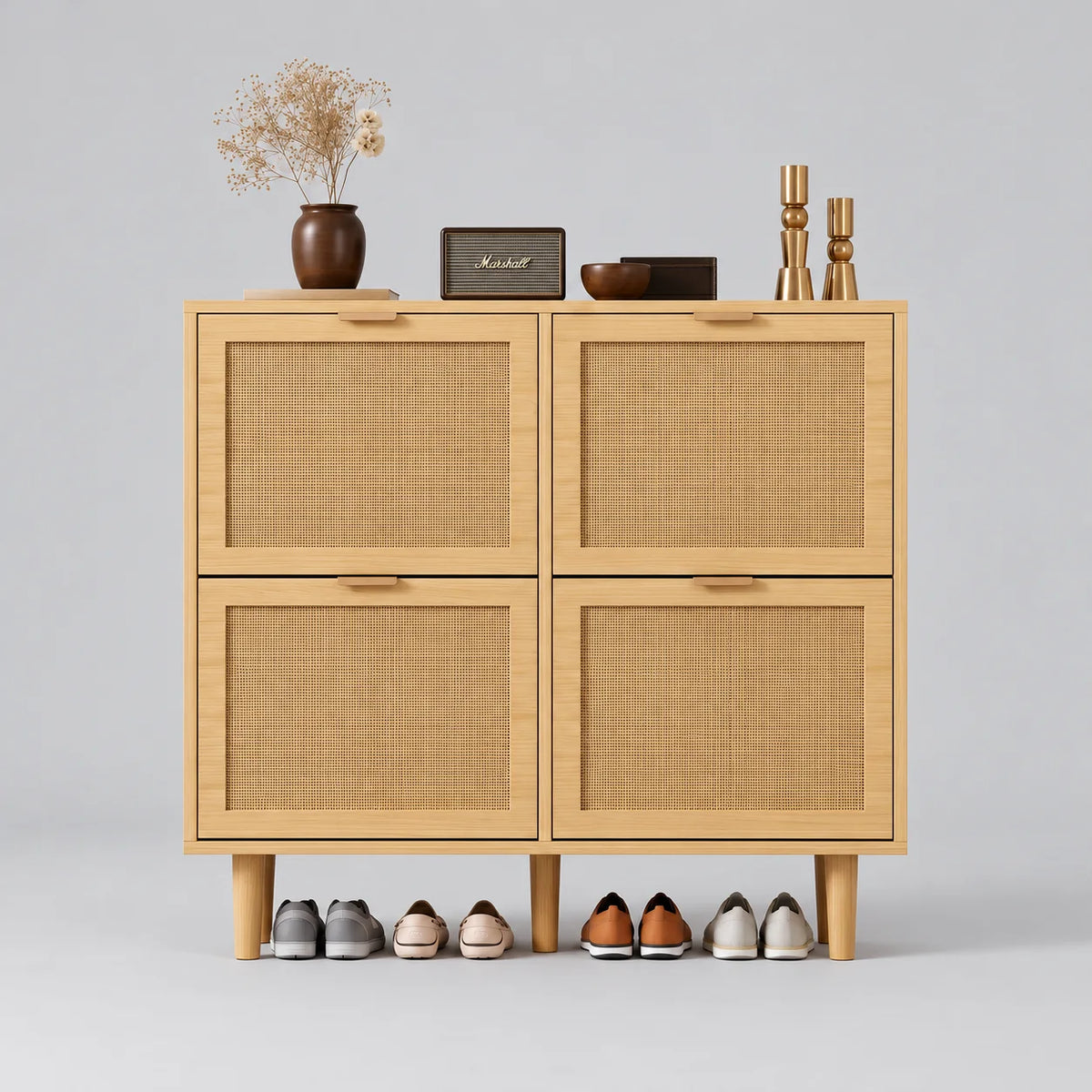 Meuble à chaussures en chêne clair à quatre façades en rotin tressé et rangement ouvert sous les pieds, sur fond gris Image