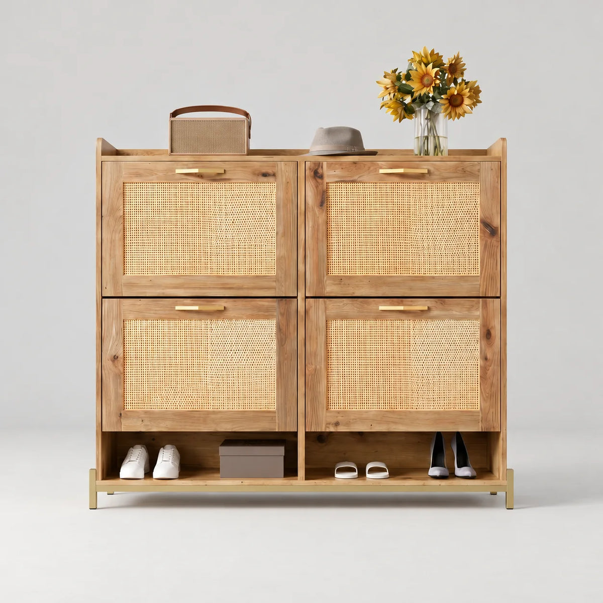 Meuble à chaussures en bois naturel avec quatre portes en cannage et poignées dorées sur fond gris