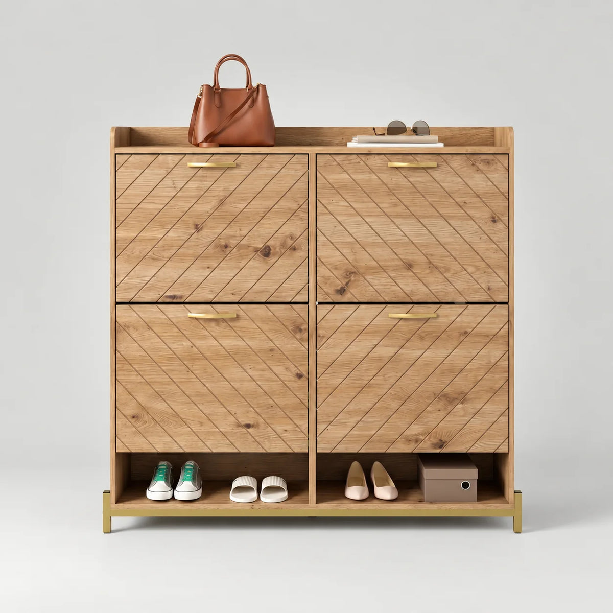 Meuble à chaussures en bois beige à quatre portes rainurées en diagonale et poignées dorées sur fond gris
