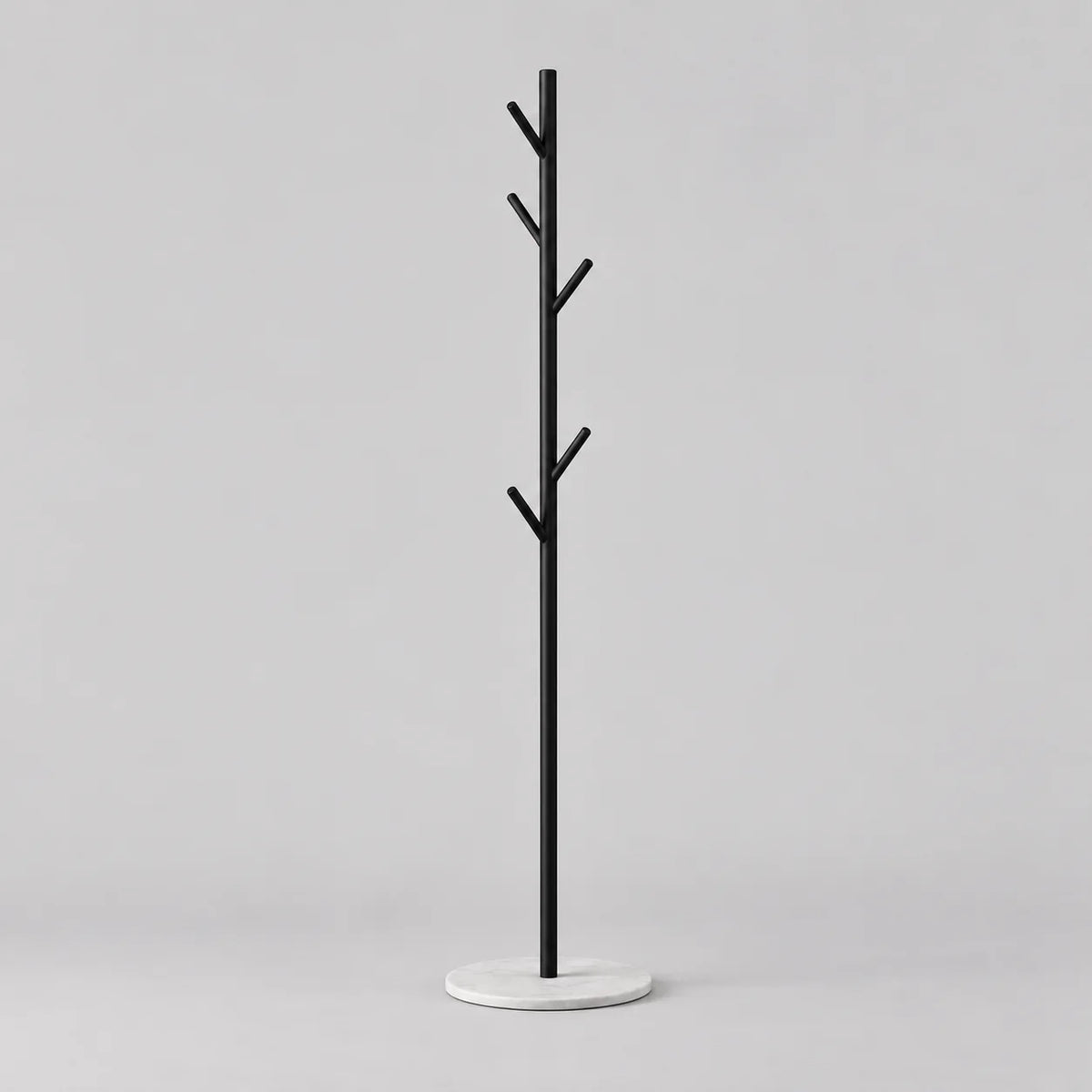 Porte-manteau arbre noir à cinq patères en branches et base ronde blanche sur fond gris