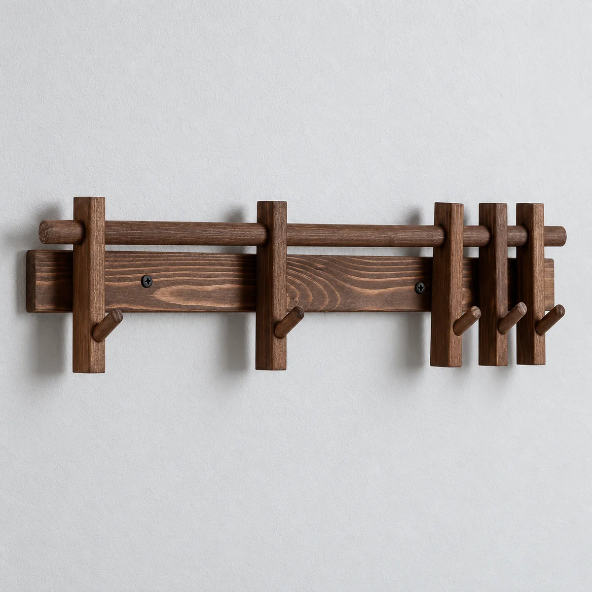 Porte-manteau mural marron en bois avec barre coulissante et crochets, sur fond gris