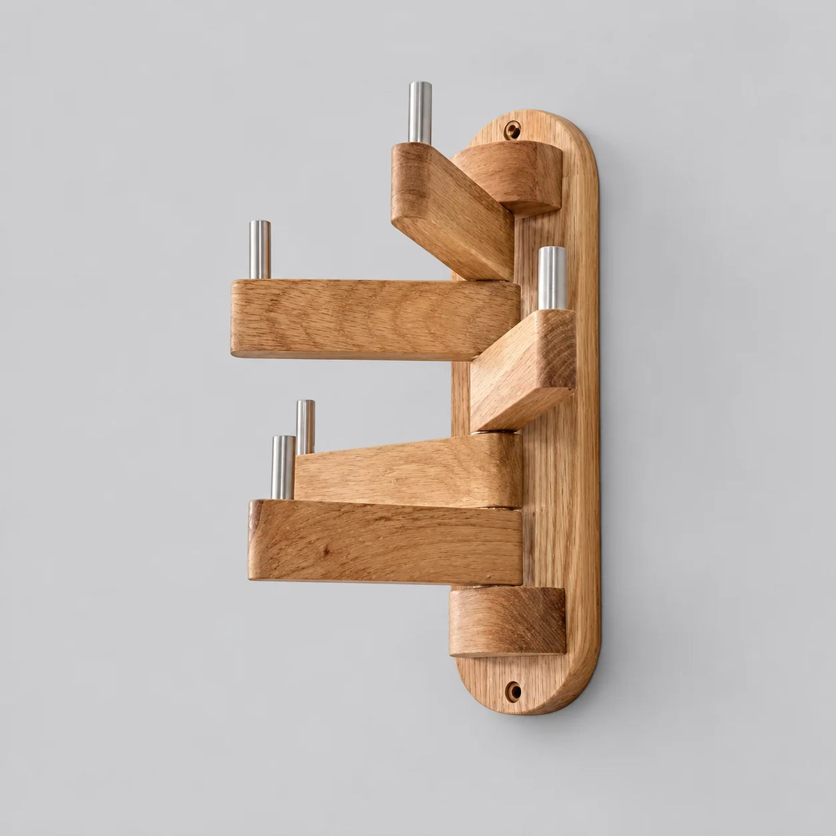 Porte-manteau mural pivotant en bois beige, cinq bras articulés et embouts métalliques, sur fond gris Image