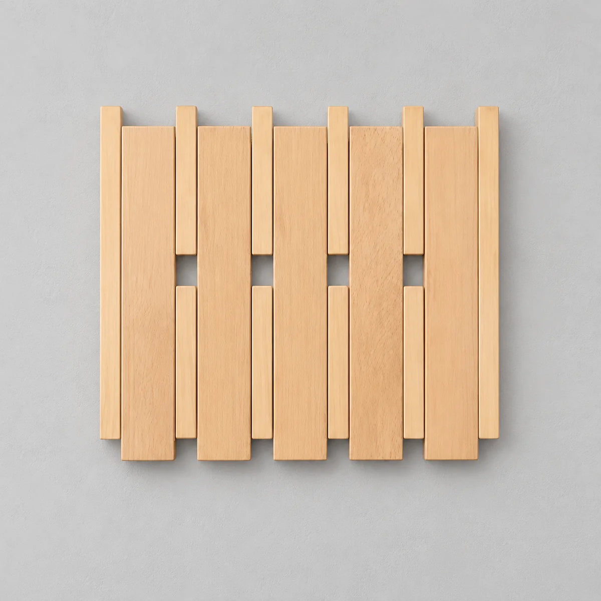 Petit porte-manteau mural carré en bois clair, lattes et crochets rabattables fermés sur fond gris