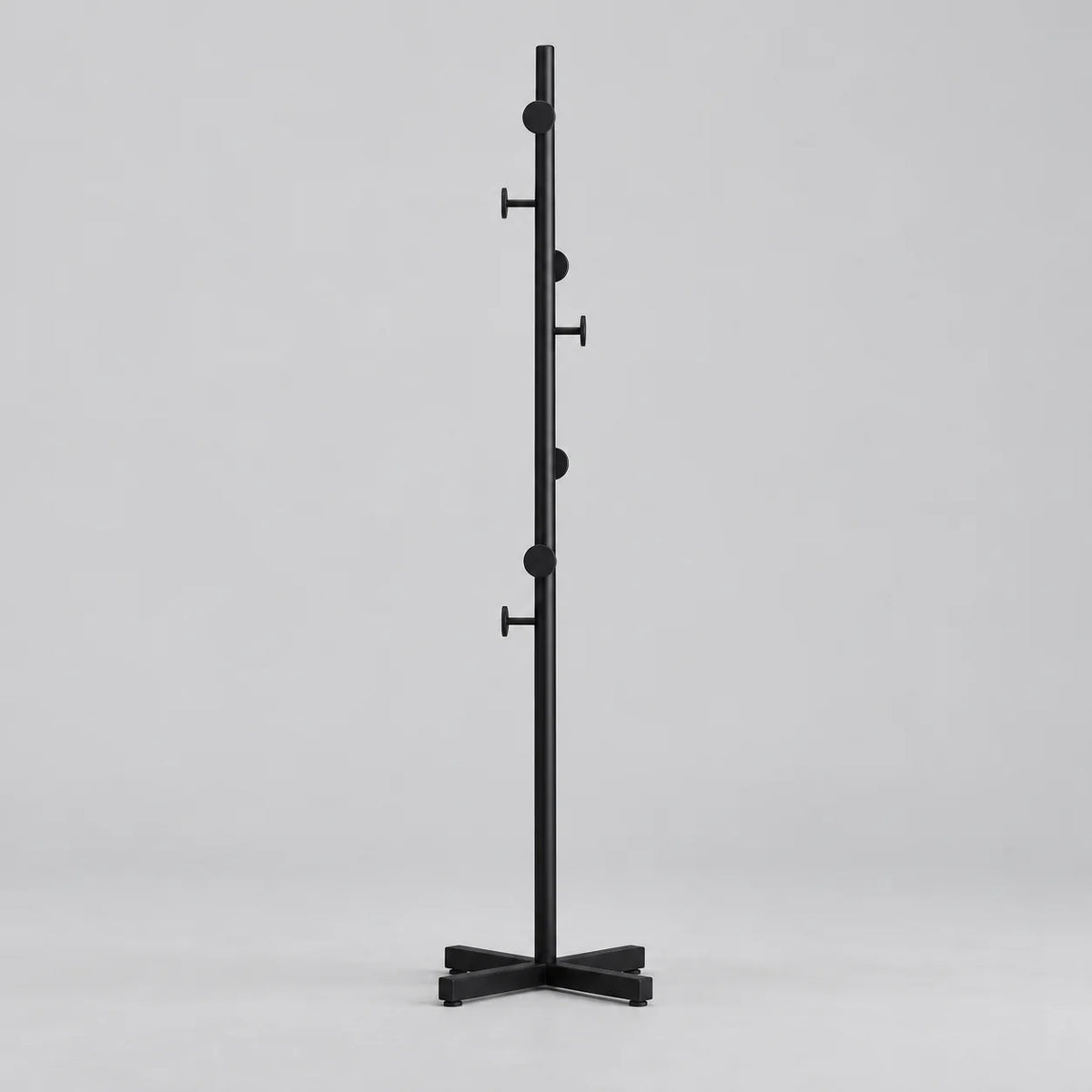 Porte-manteau champignon noir à patères rondes et base croisée sur fond gris