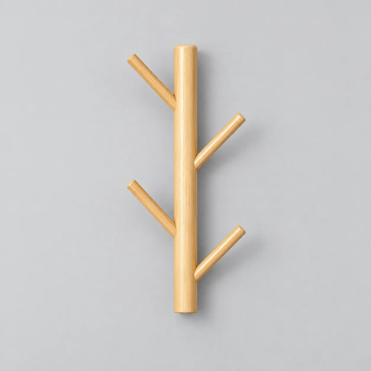 Porte-manteau mural en bois clair avec quatre branches sur fond gris