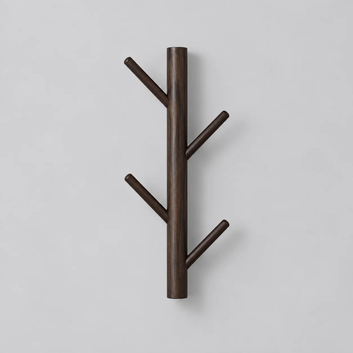 Porte-manteau mural en bois foncé à quatre branches sur fond gris