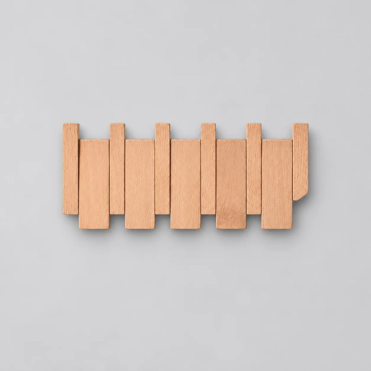 Porte-manteau mural compact en bois de hêtre clair à lames alternées sur fond gris Image