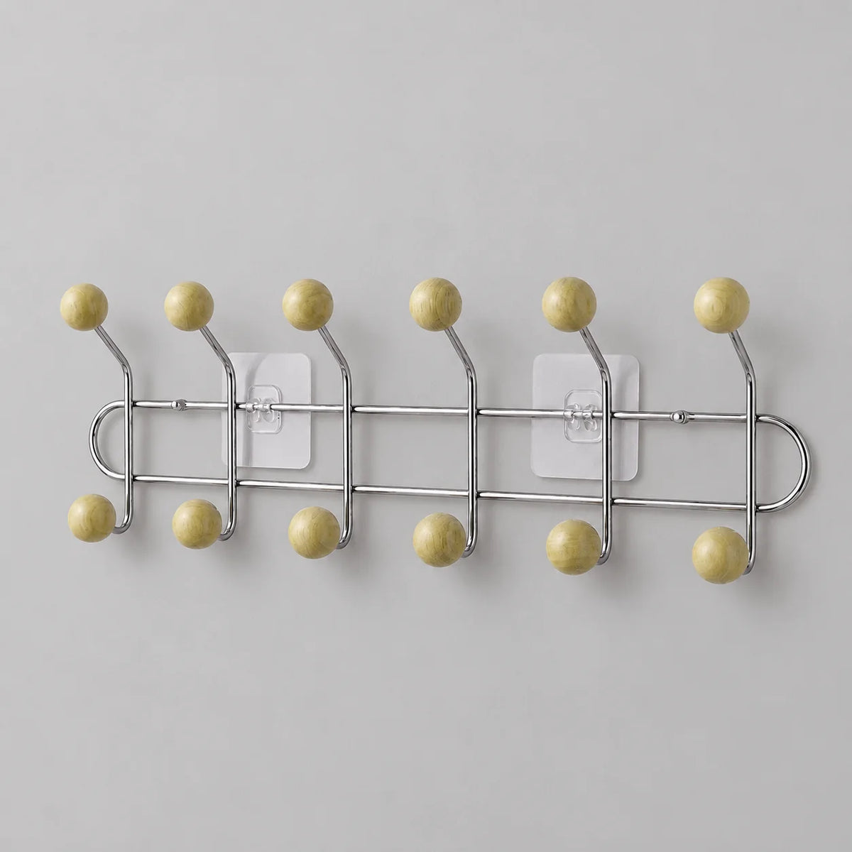 Porte-manteau mural chromé à six bras et douze boules bois jaune crème sur fond gris