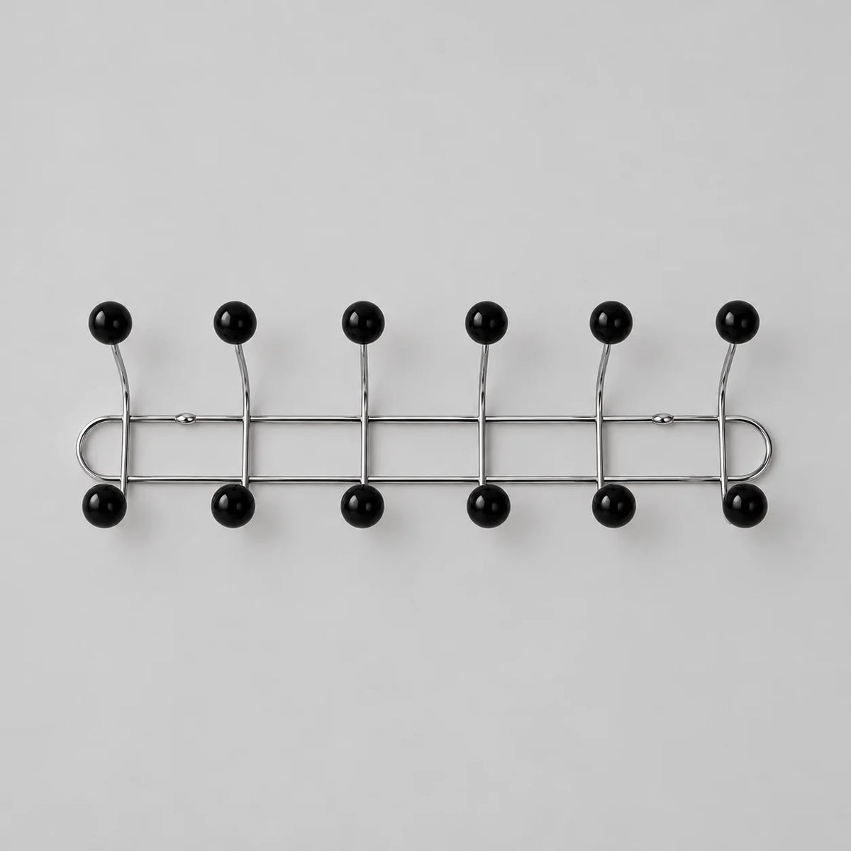 Porte-manteau mural chromé à six bras et douze boules noires sur fond gris Image