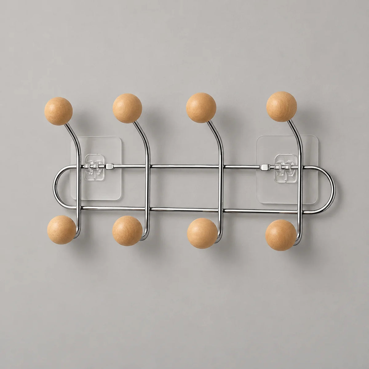 Porte-manteau mural chromé à huit boules bois abricot sur fond gris