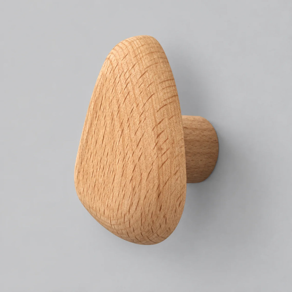 Patère murale ovale en bois naturel clair sur fond gris