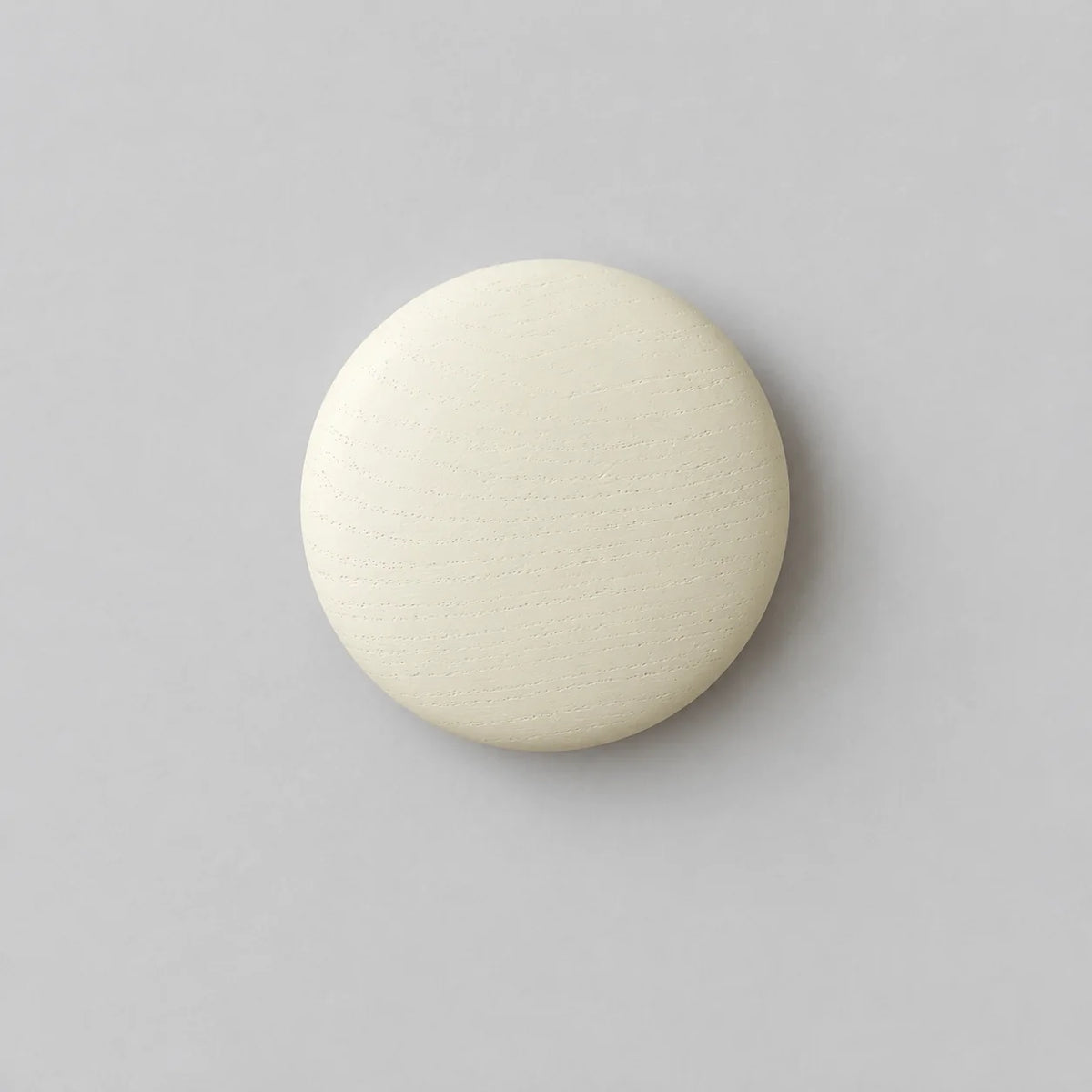 Patère murale ronde blanche en bois sur fond gris