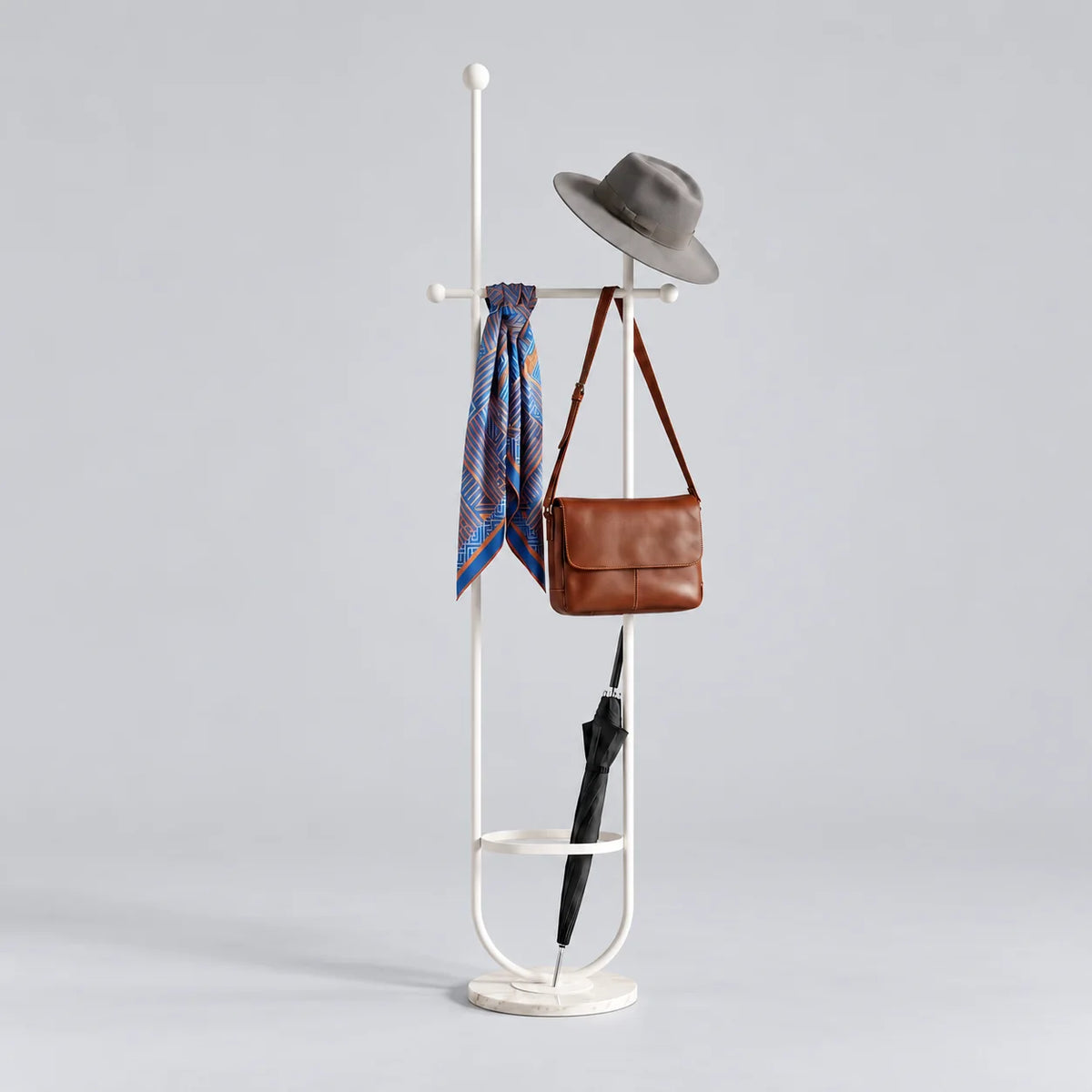 Porte-manteau sur pied en métal blanc à deux montants, traverse à boules, anneau porte-parapluie et base ronde blanche veinée, avec chapeau, foulard, sac et parapluie