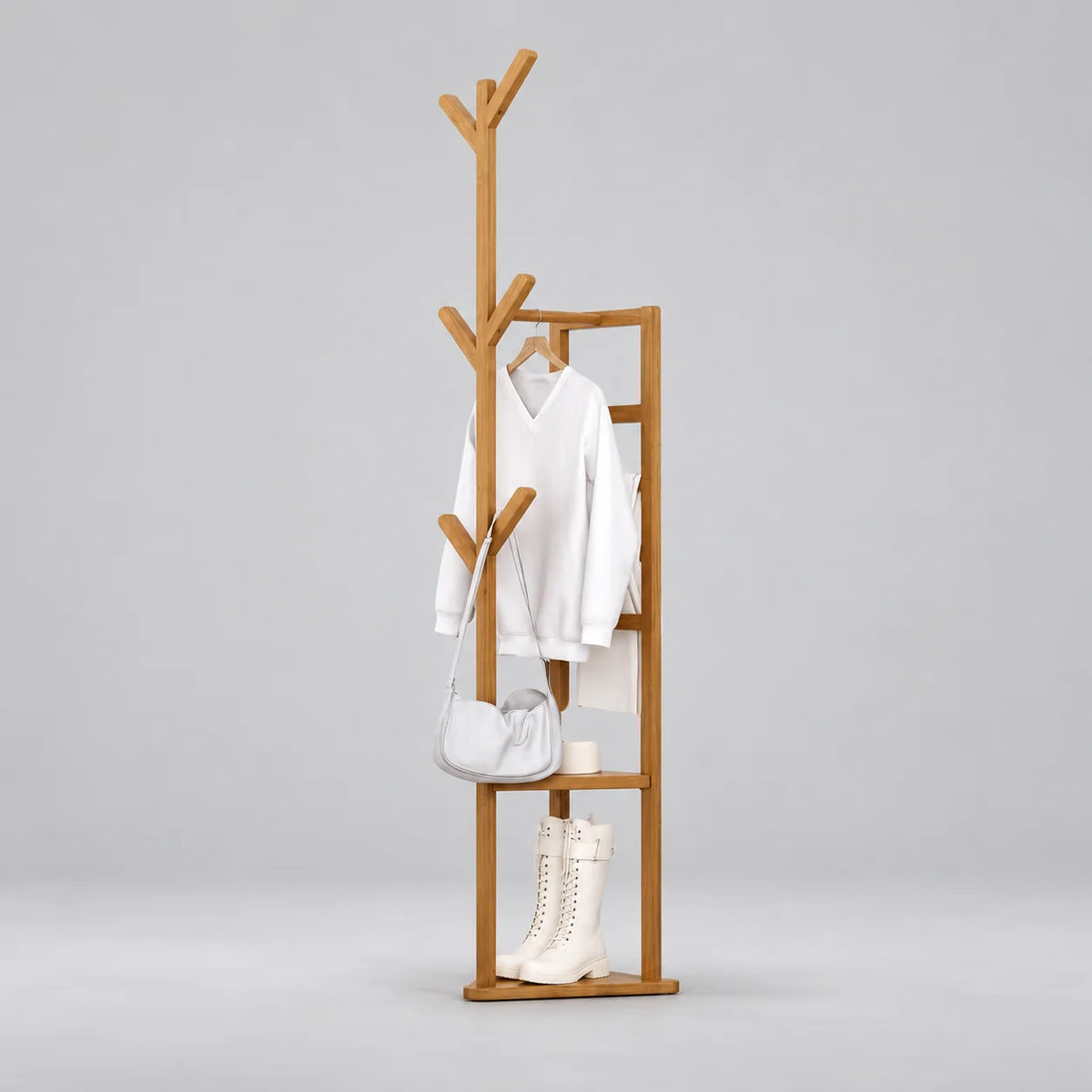 Porte-manteau multifonction en bois clair avec branches et rangement à chaussures, sur fond gris