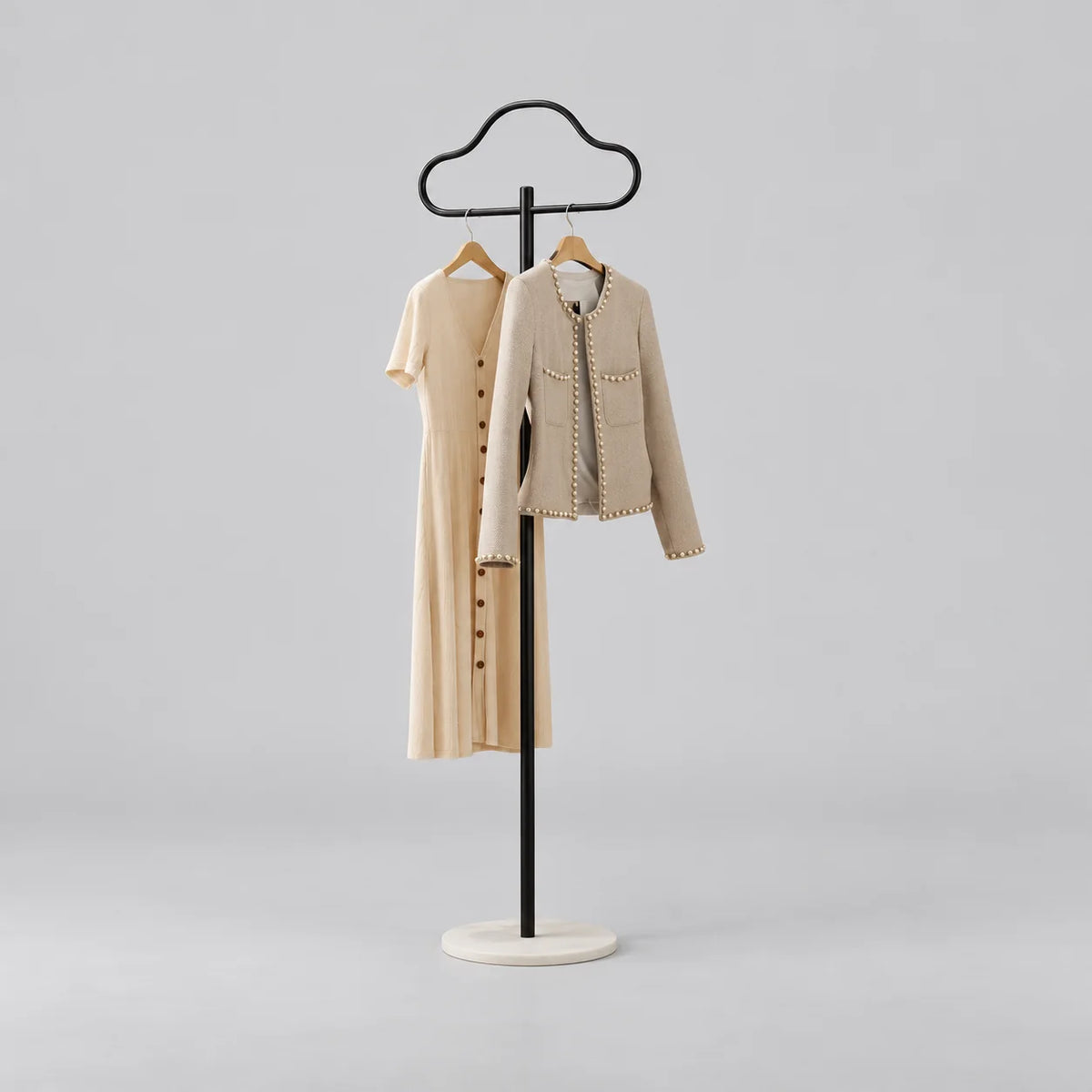 Porte-manteau sur pied Nuage noir avec vêtements et socle rond blanc sur fond gris
