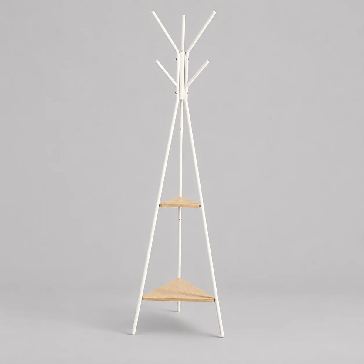 Porte-manteau trépied en métal blanc avec deux étagères en bois clair sur fond gris