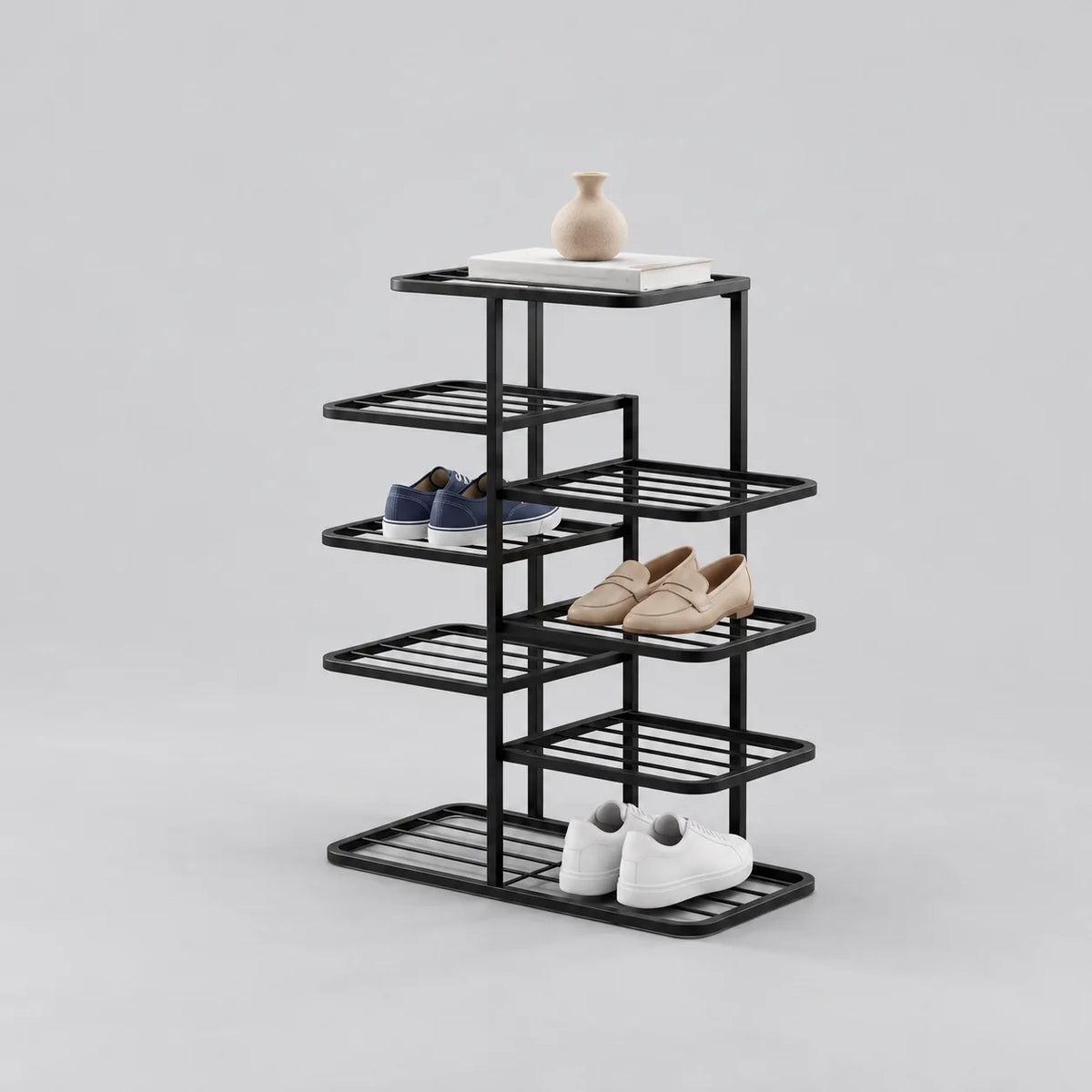 Range-chaussures noir en fer forgé à étagères alternées, avec vase et trois paires de chaussures, sur fond gris
