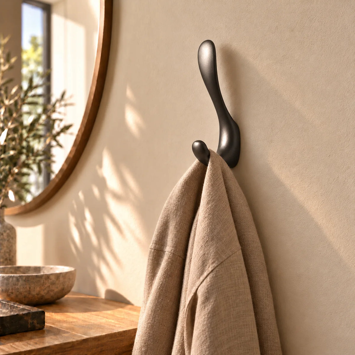 Patère crochet gris avec écharpe taupe suspendue dans une entrée