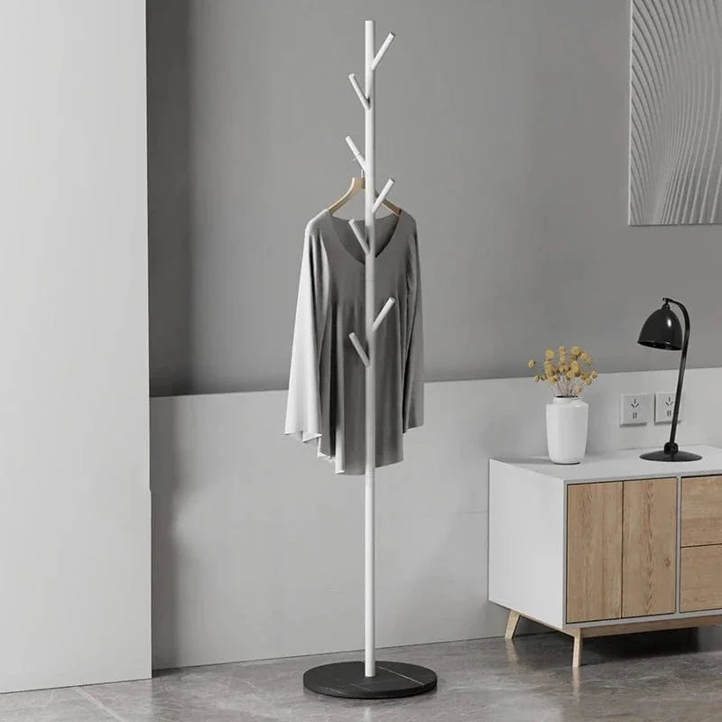 Porte-manteau arbre blanc sur pied noir marbré avec vêtement gris dans une entrée