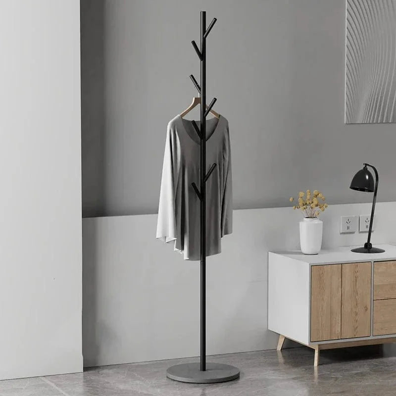 Porte-manteau arbre noir sur base grise dans une entrée, photo du produit original