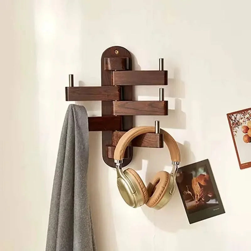 Porte-manteau mural pivotant en bois foncé avec écharpe et casque suspendus dans une pièce