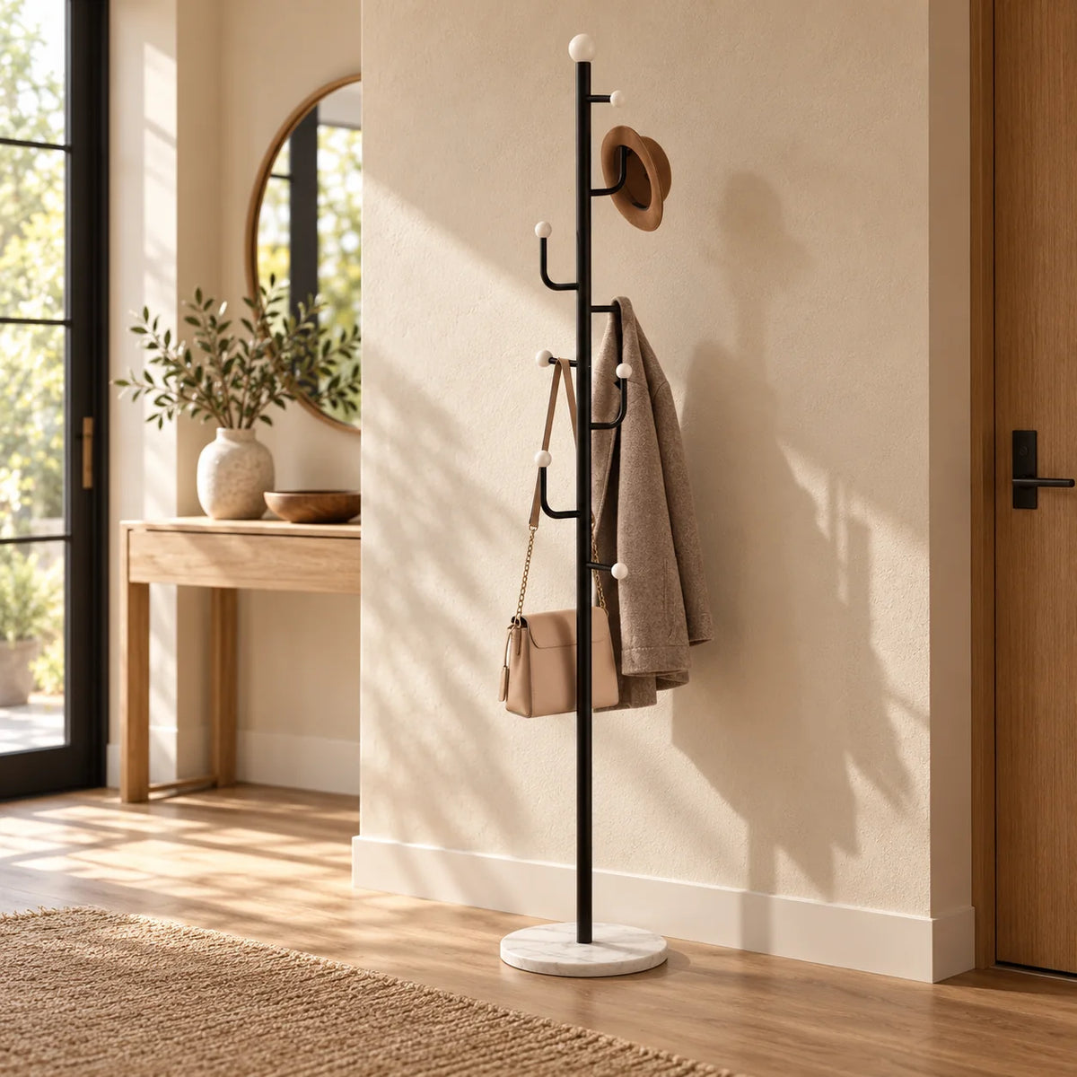 Porte-manteau noir à base ronde blanche dans une entrée décorée avec vêtements Image