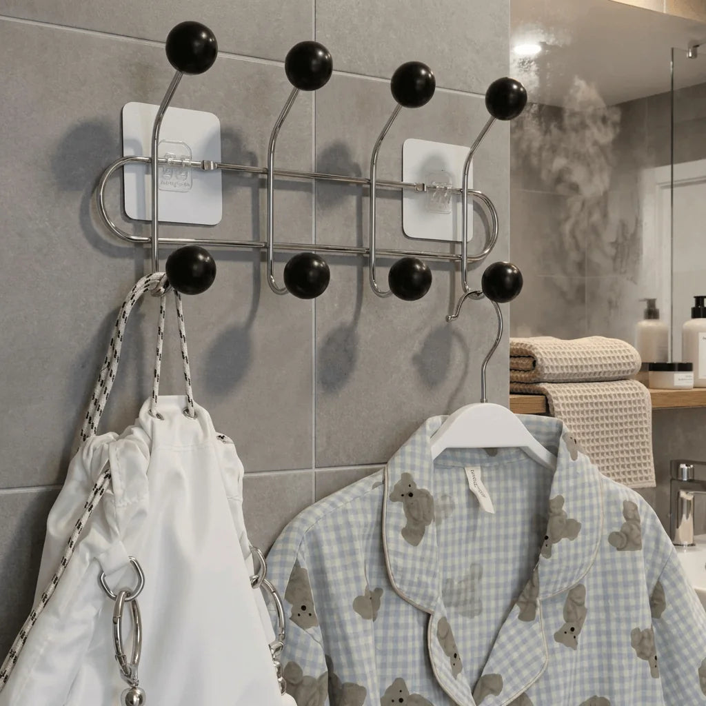 Porte-manteau mural chromé à boules noires dans une salle de bain, photo originale