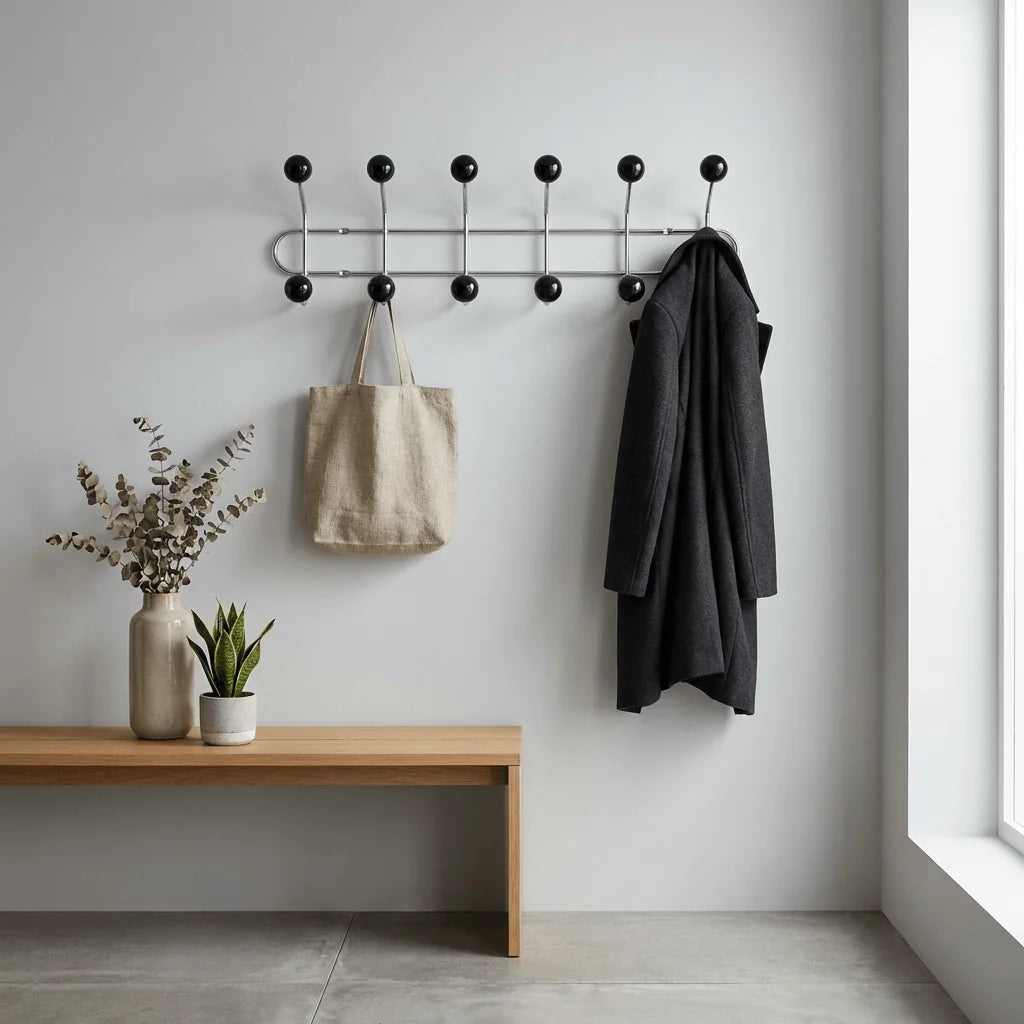 Porte-manteau mural chromé à boules noires dans une entrée, photo originale