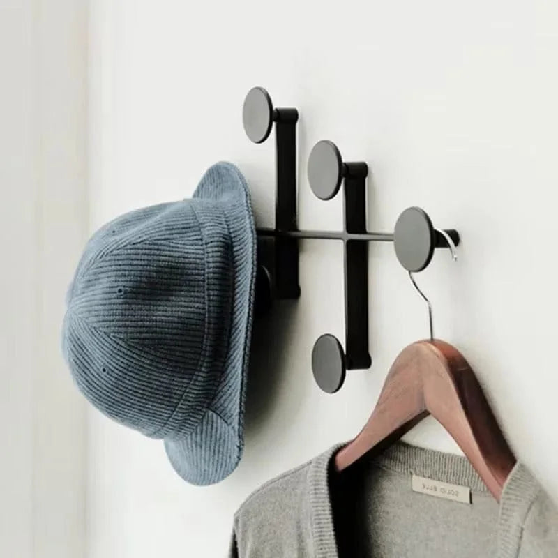 Détail du porte-manteau mural noir à patères rondes avec chapeau bleu et veste suspendus