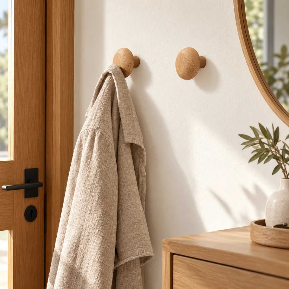 Patères rondes en bois naturel avec veste en lin dans une entrée