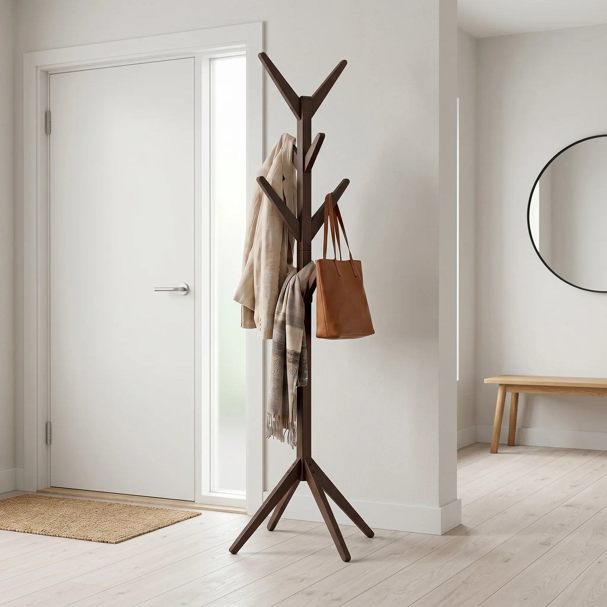 Porte-manteau arbre en bois foncé dans une entrée avec manteau et sac