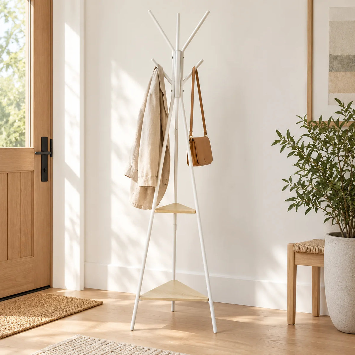 Porte-manteau trépied blanc avec manteau et sac dans une entrée claire