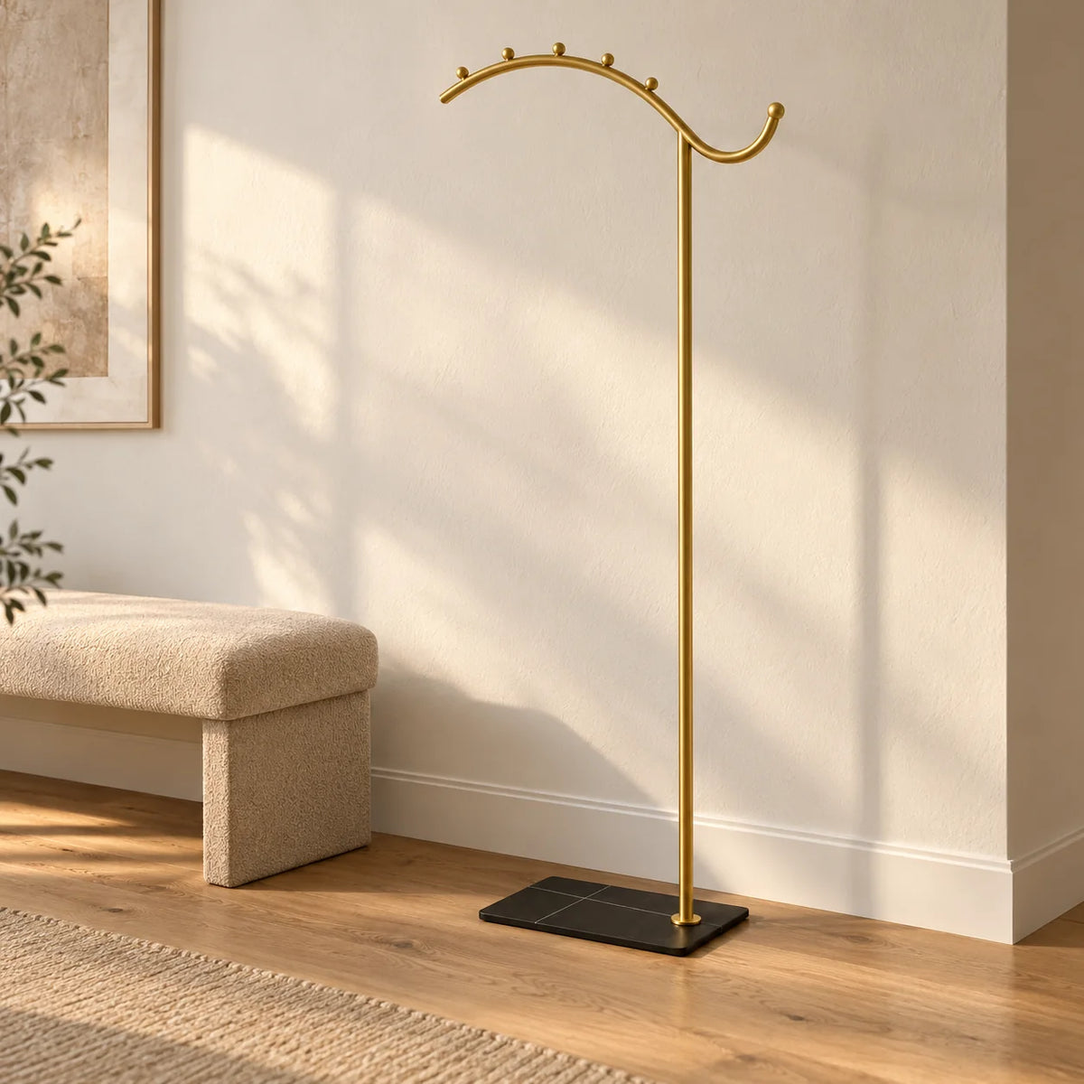 Porte-manteau voûte dorée à socle noir dans une entrée ensoleillée, entièrement visible Image