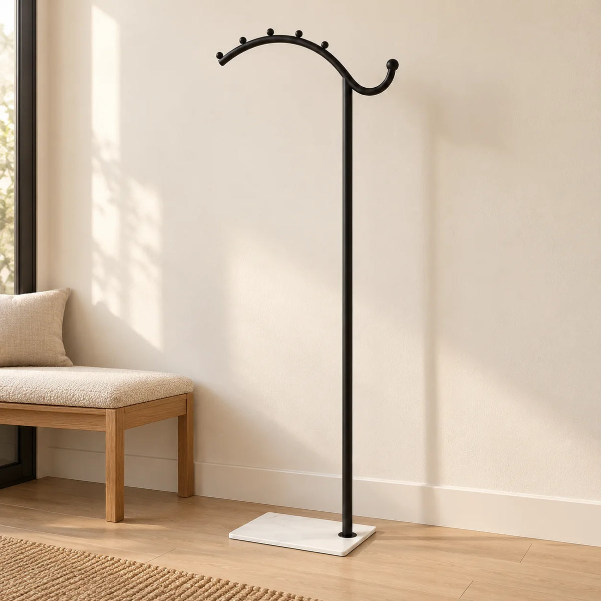 Porte-manteau voûté noir à socle blanc dans une entrée, structure entièrement visible