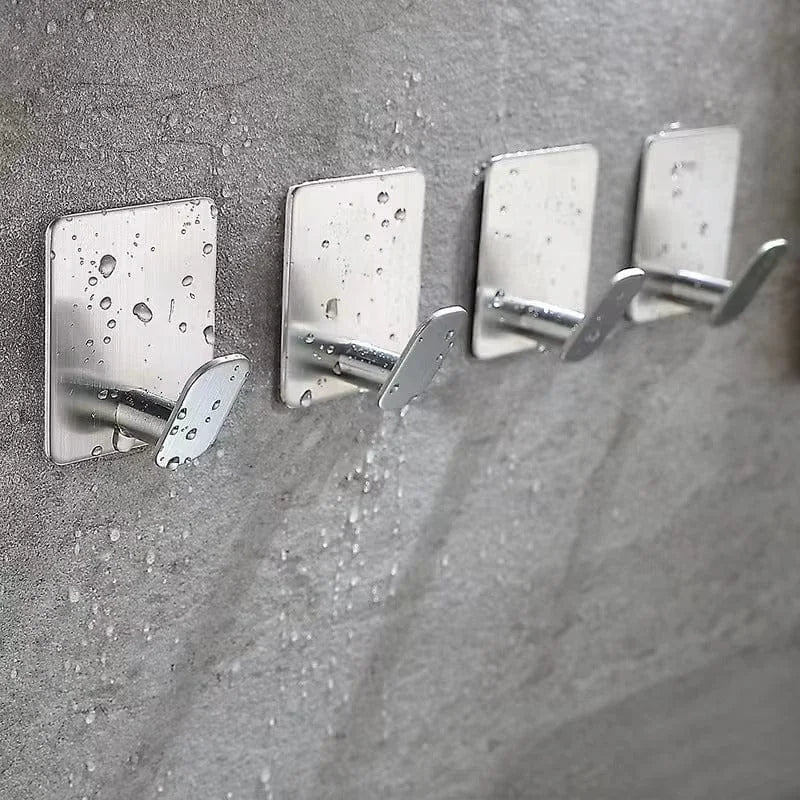 Photo d'origine de quatre crochets inox installés sur un mur de salle de bain