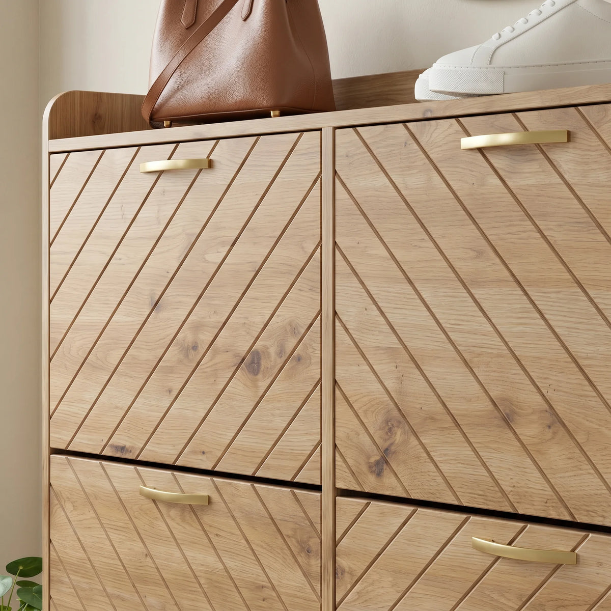 Détail du grain de bois, des rainures diagonales et des poignées dorées des portes hautes