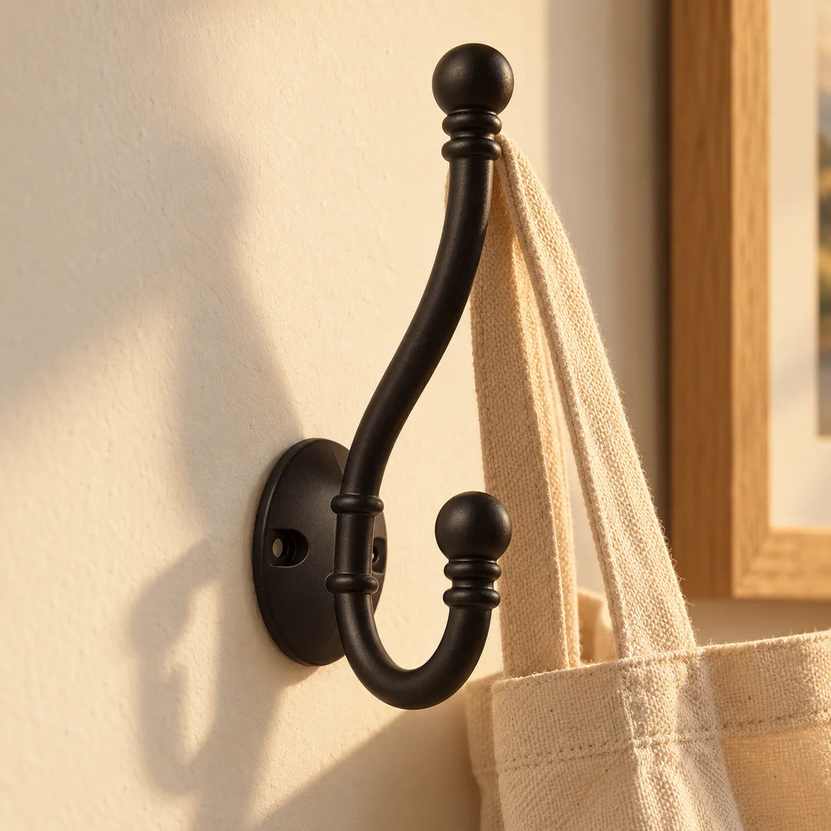 Patère double noire dans une entrée avec un sac en toile suspendu au crochet supérieur