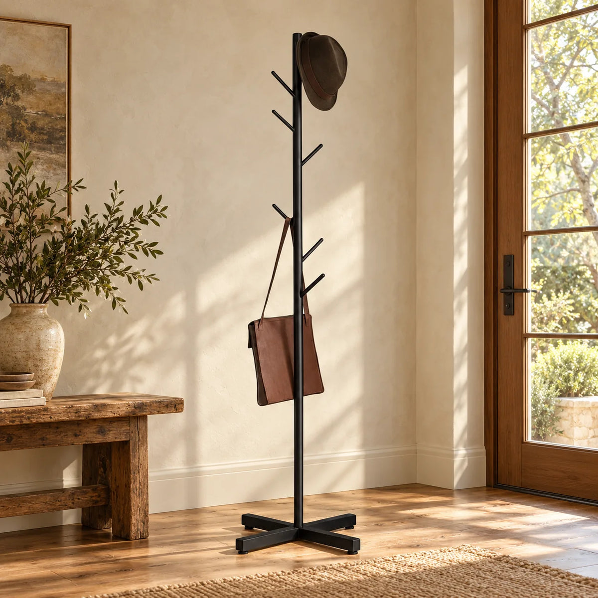 Porte-manteau arbre noir avec chapeau et sac dans une entrée chaleureuse
