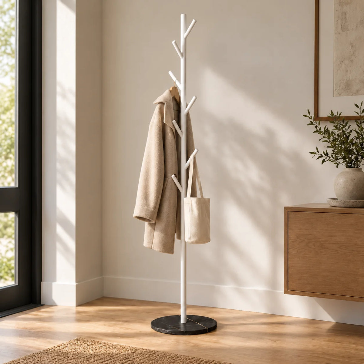 Porte-manteau arbre blanc à sept patères et base noire marbrée dans une entrée avec manteau et sac