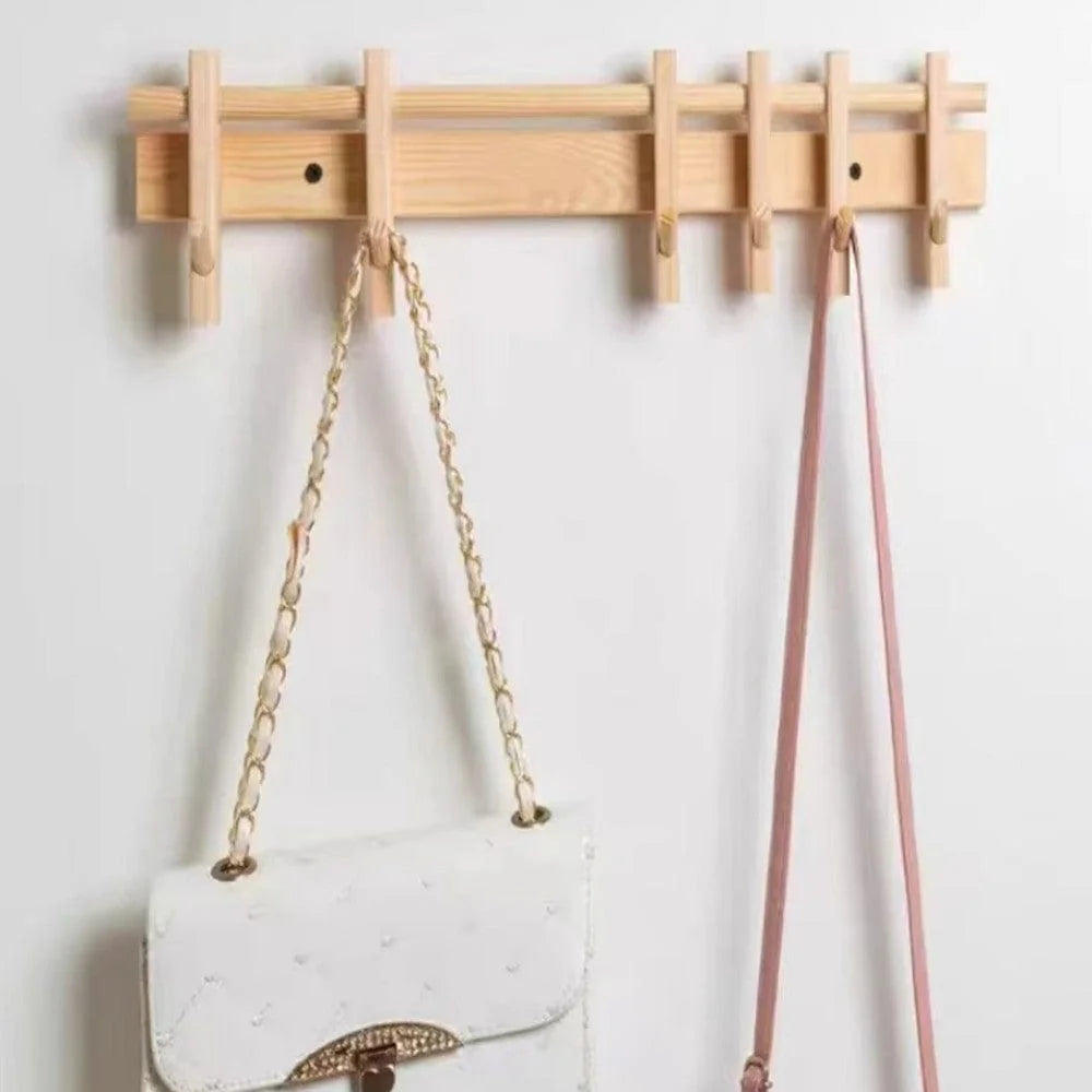 Patère murale en bois clair avec six crochets et sacs suspendus