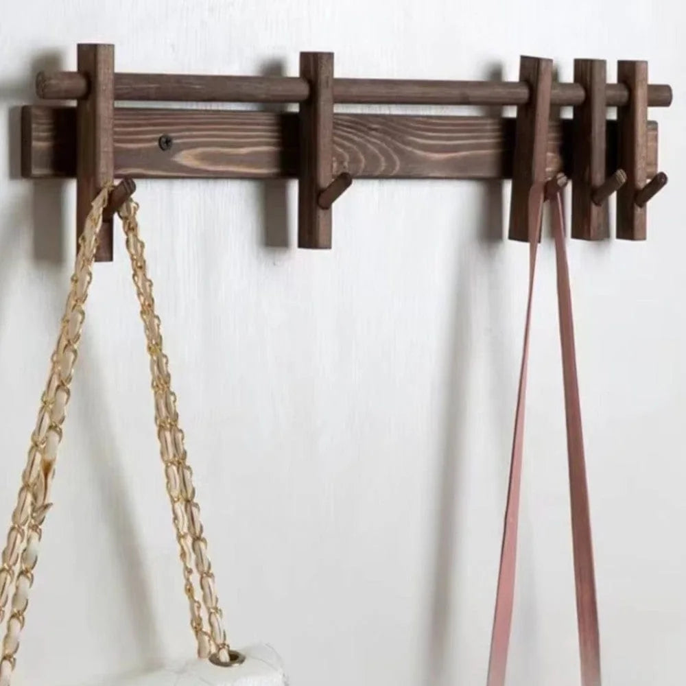 Patère murale en bois foncé avec crochets coulissants et sacs suspendus