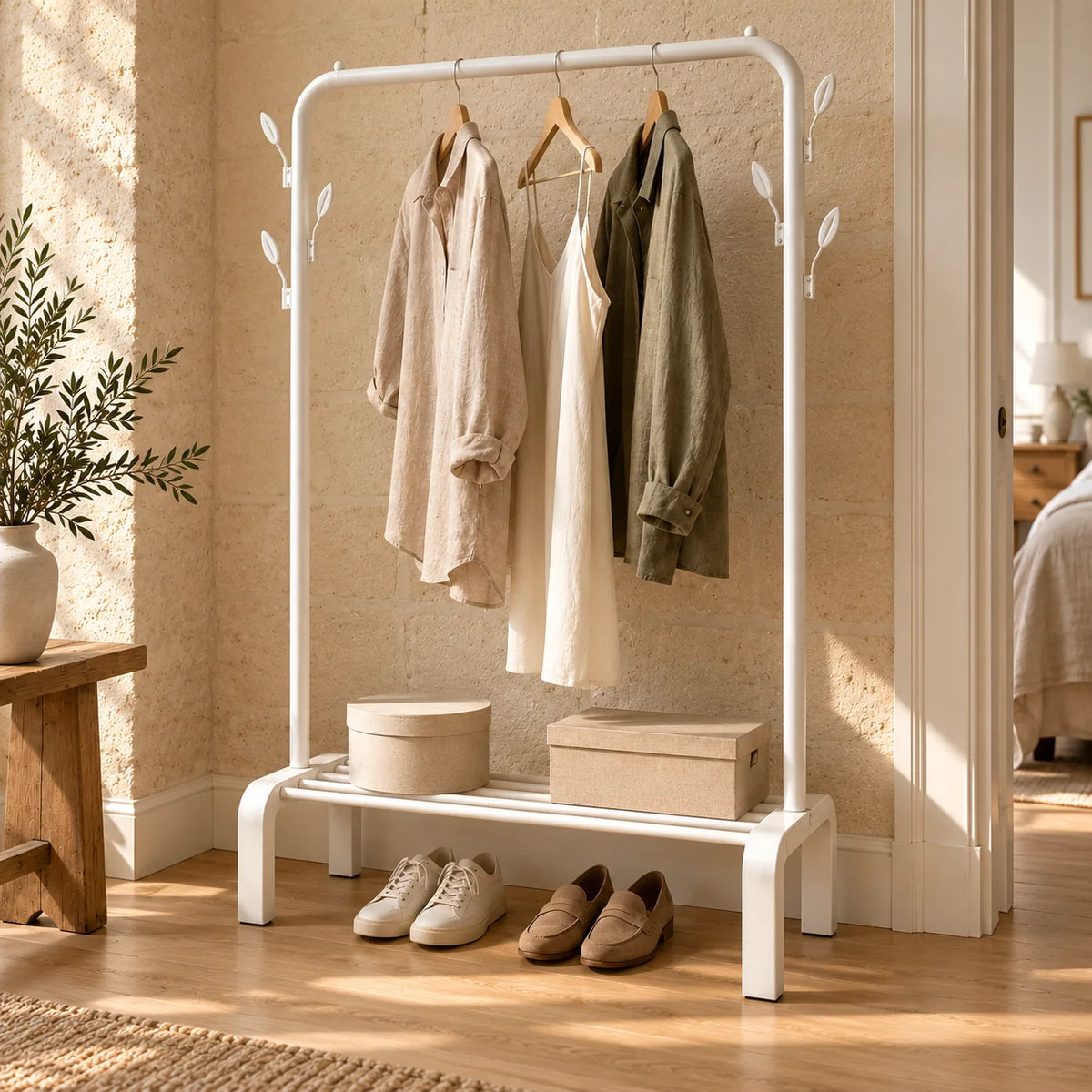Portant dressing blanc vu en angle près d’une fenêtre, avec vêtements et rangements