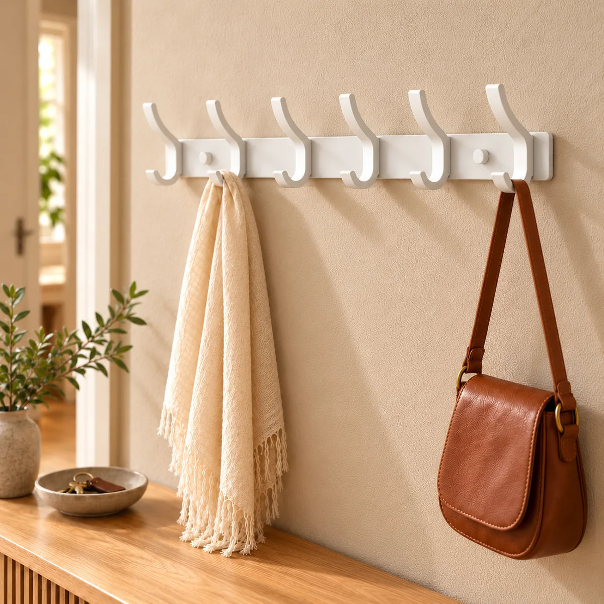 Vue rapprochée du porte-manteau blanc à six crochets dans la même entrée