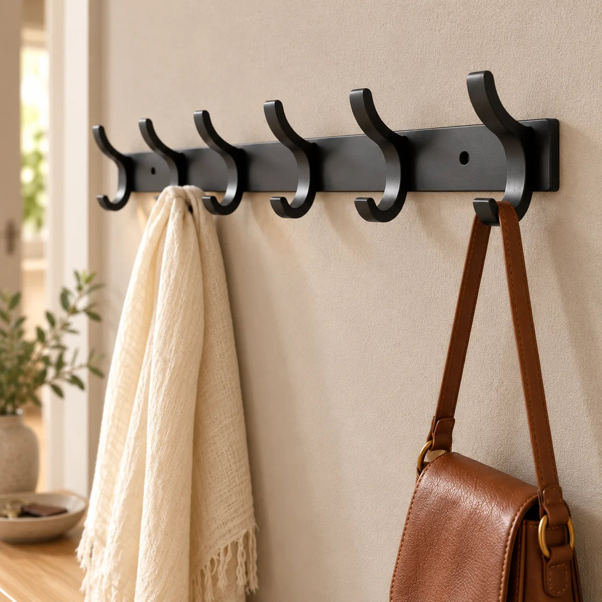 Vue rapprochée en biais du porte-manteau noir à six crochets dans la même entrée